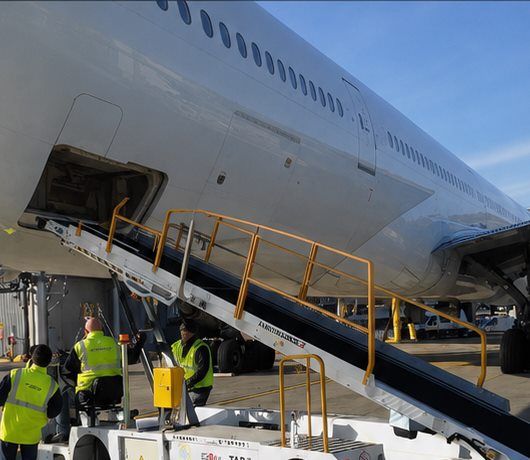 Belt loader and ramp team beside an aircraft